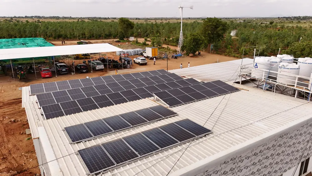Rooftop solar panels and a wind turbine powering the GreenX farm campus